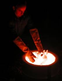 red-hot pots being lifted from the kiln for smoking